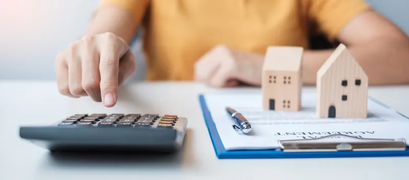 woman using calculator during signing home contract documents contract agreement, real estate, buy and sale and insurance concepts
