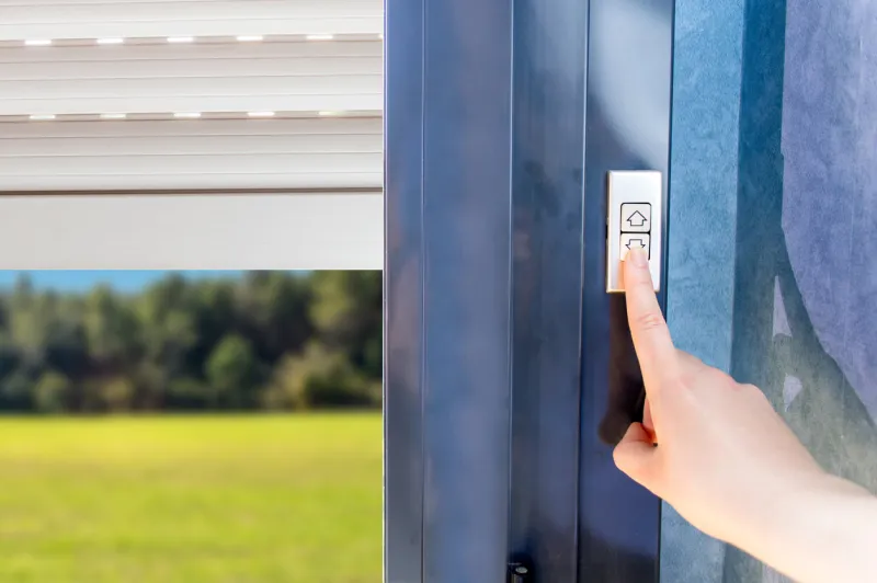 woman lifting electric shutters in house