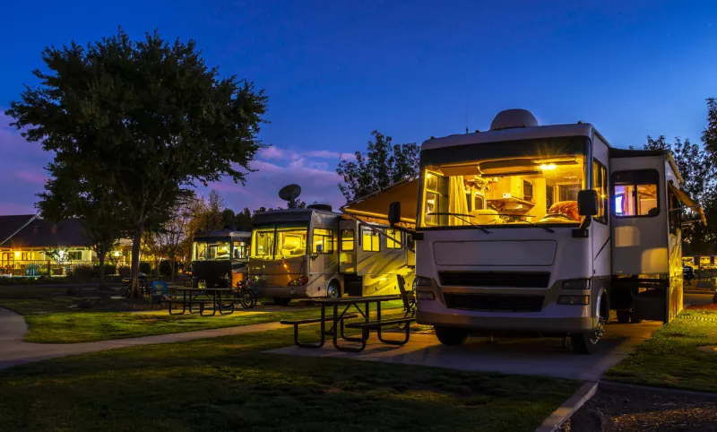 rving at a resort in the evening lighted sky with class a rigs interior lights on