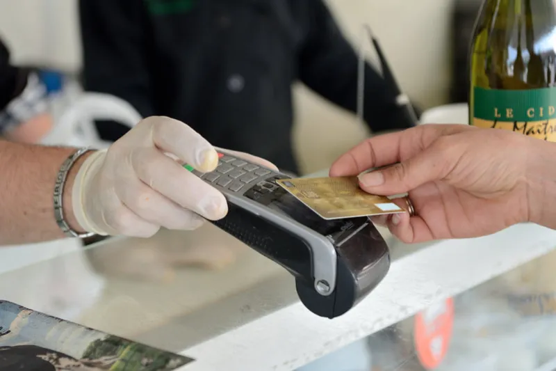 normandy, france, april 2020health crisis covid-19 using preventive measures on an open-air market of farm producers wearing protective gloves payment by credit card using option contactless