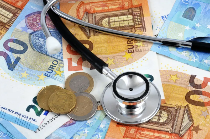 concept of the cost of health with a stethoscope on banknotes and euro coins in close-up