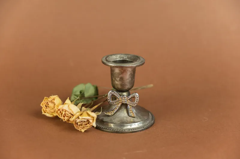 old candle holder and yellow roses against a brown background melchior alloy candle holder a branch of dried yellow flowers