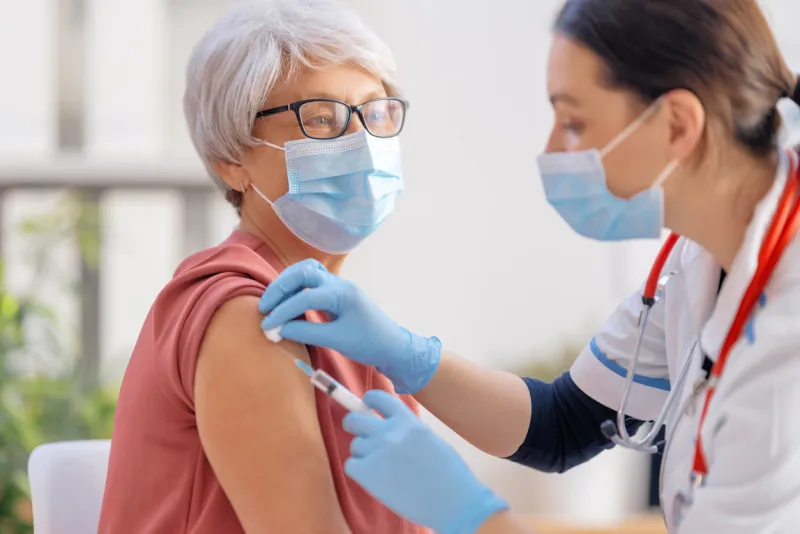 doctor vaccinating a senior woman virus protection covid-2019