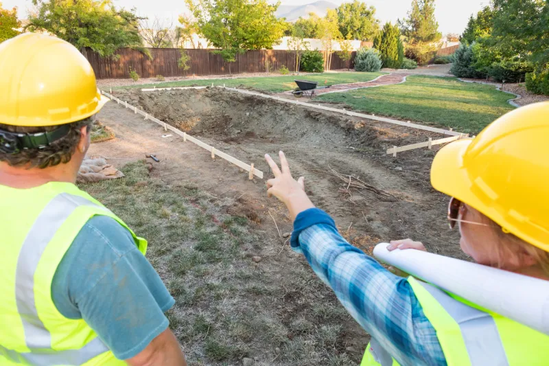 male and female workers overlooking pool construction site