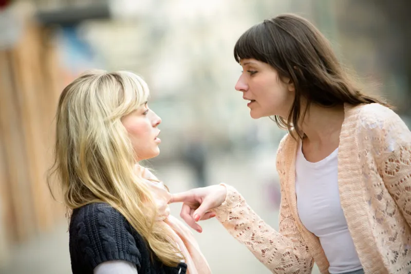 two women talking to each other and arguing