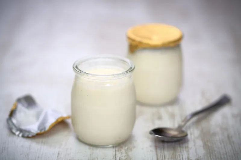 yogurt in a glass jars with spoon on wooden background
