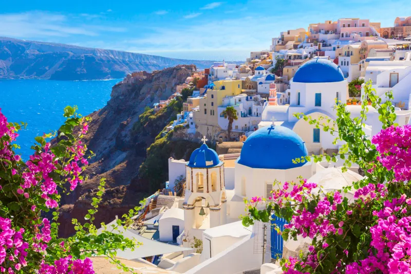 santorini island, greece oia town traditional white houses and churches with blue domes over the caldera, aegean sea