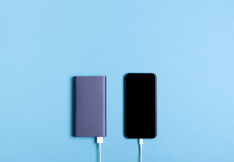 smartphone charging with power bank on blue background