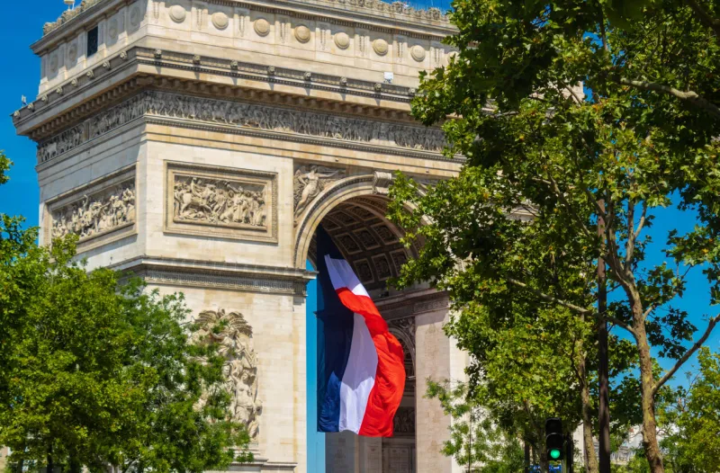 paris, france - july 17th 2022  paris triumphal arch with a french flag, arc de triomphe