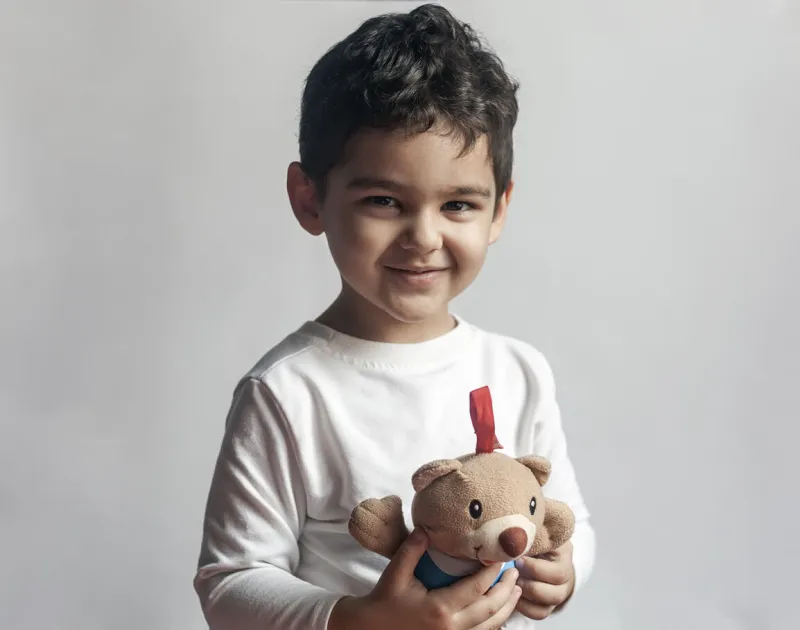portrait of 4-5 years adorable old boy playing with soft plush cute bear toy