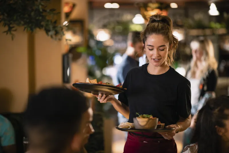 a waitress serving customers food at a restaurant in newcastle-upon-tyne
