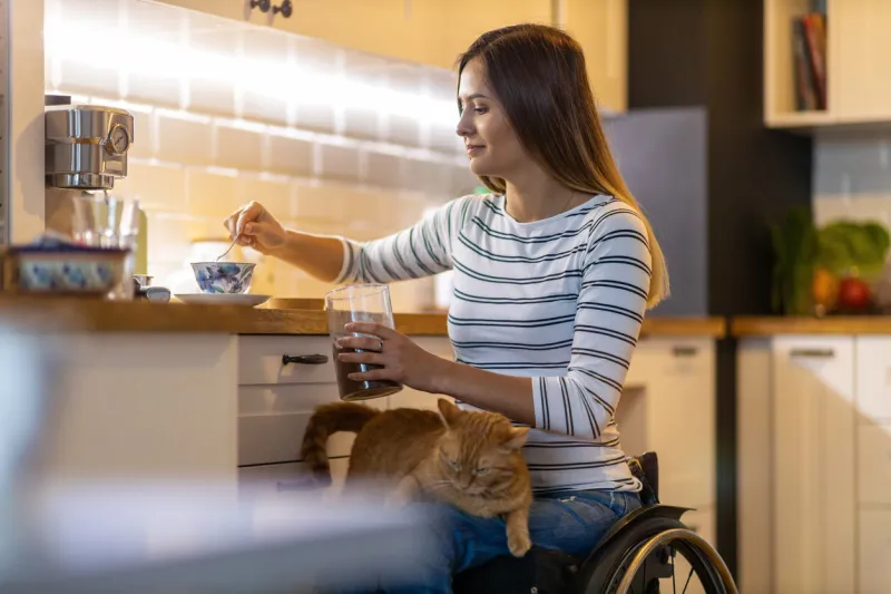 woman in wheelchair in kitchen at home