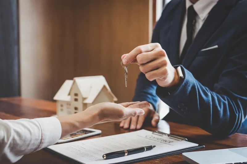 real estate agent sales manager holding filing keys to customer after signing rental lease contract of sale purchase agreement, concerning mortgage loan offer for and house insurance