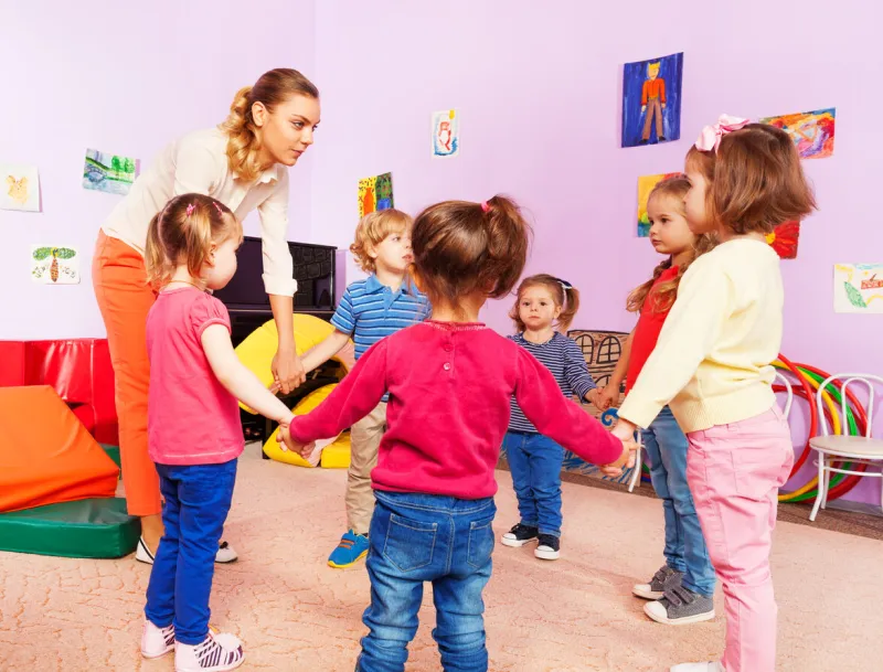 teacher and group of kids in kindergarten roundelay in kindergarten lesson