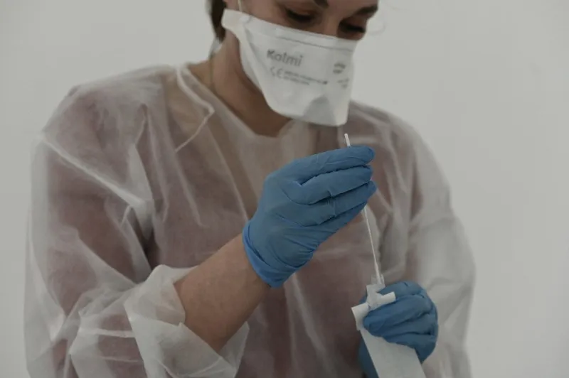 a medical staff member dressed with protective gear conducts a covid-19 test, on the first day of a massive screening campaign, in saint-etienne, on january 13, 2021 (photo by jean-philippe ksiazek   afp)