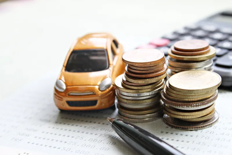 business, finance, saving money, banking or car loan concept   miniature car model, coins stack, calculator and saving account book or financial statement on office desk table