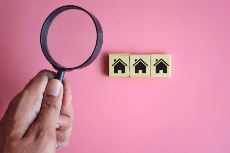 search, inspection house concept hand holding magnifying glass and wooden cubes with house icon