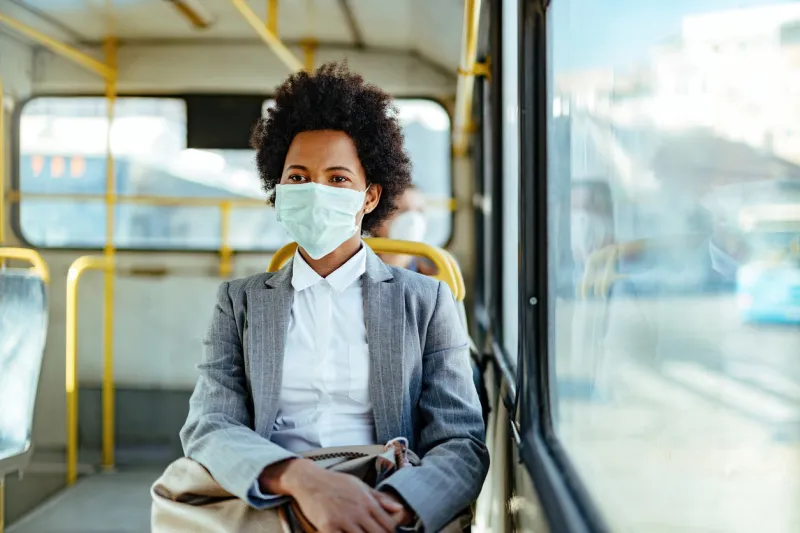 african american businesswoman wearing protective mask while traveling by public transportation