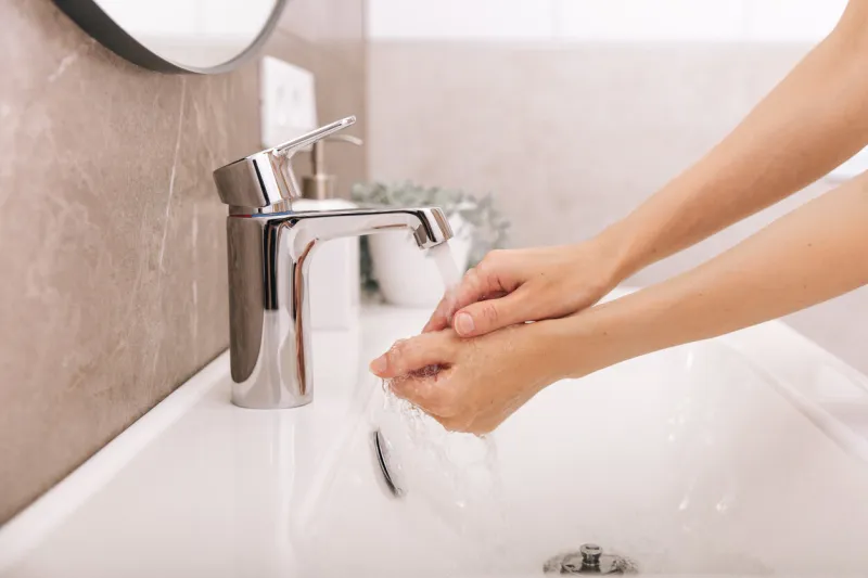 washing hands under the flowing water tap washing hands rubbing with soap for corona virus prevention, hygiene to stop spreading corona virus in or public wash room hygiene concept hand detail