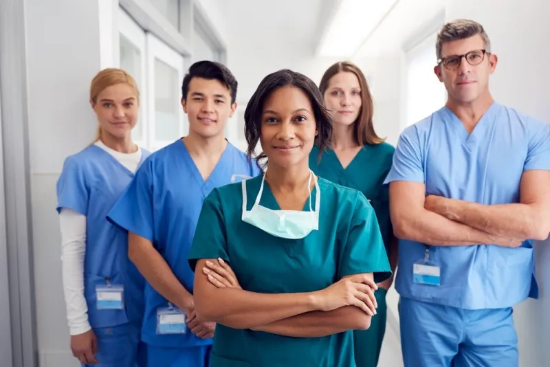 portrait of multi-cultural medical team standing in hospital corridor