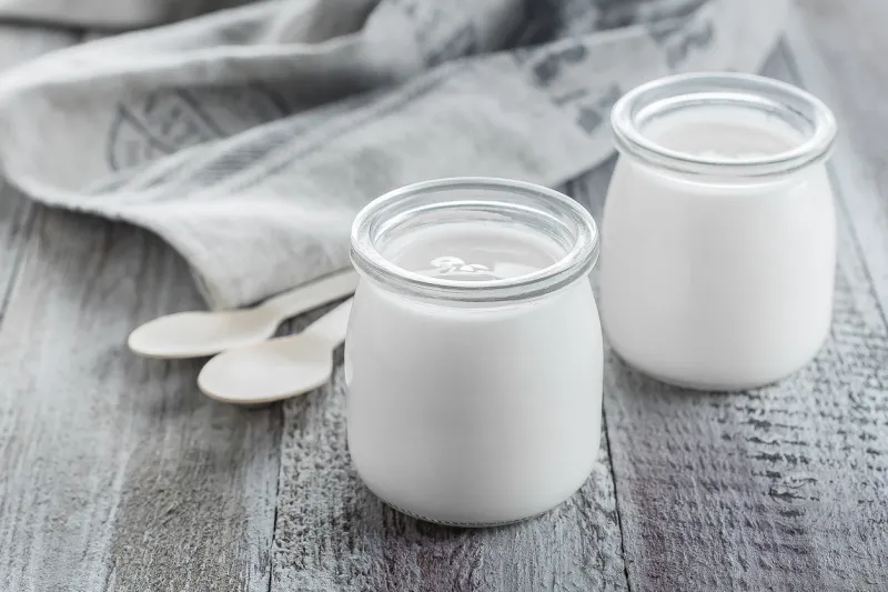 greek yogurt in a glass jars with wooden spoons on wooden background healhty breakfast food copy space