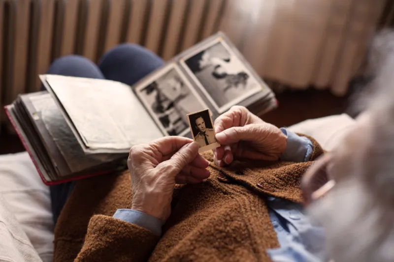 senior adult woman looking at an old photo of her husband