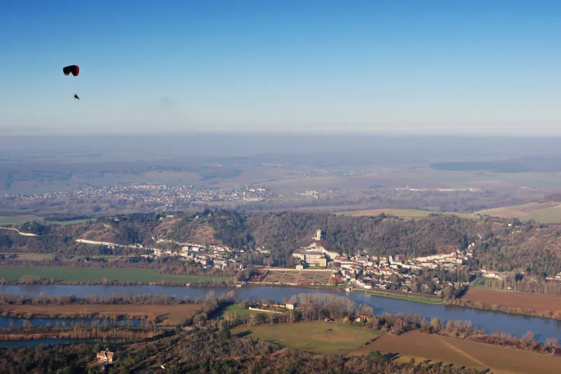 aerial photography of a paramotor over flying la roche-guyon en vexin and its castle, in val-d'oise department (95780), region ile-de-france, france - january 03