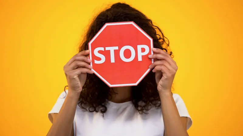 young woman showing stop sign, protesting against racism and violence, awareness