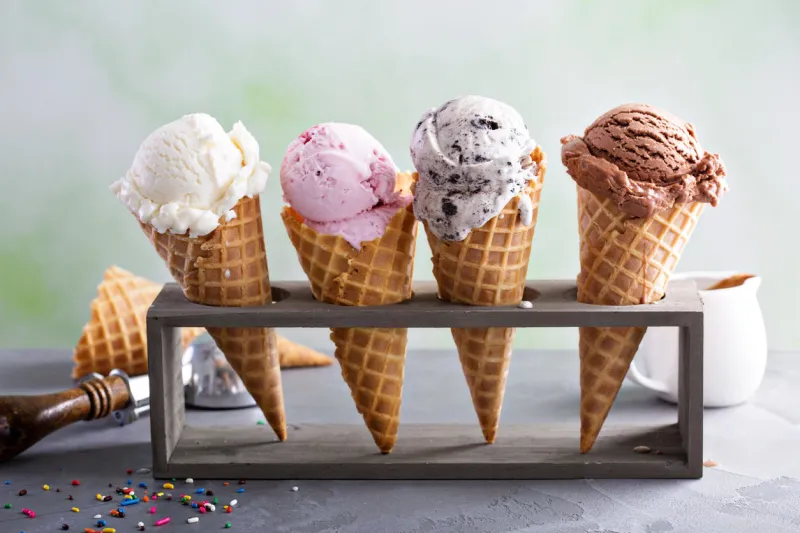 variety of ice cream scoops in cones with chocolate, vanilla and strawberry