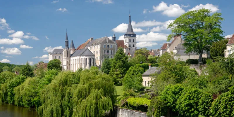 the french village of saint gaultier and its church surrounded with trees, stand on the banks of the creuse river by a sunny springtime day