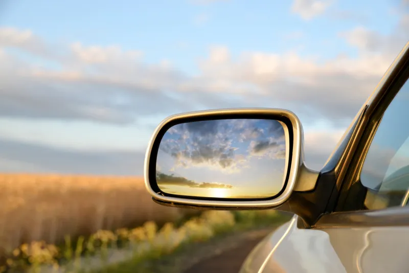 sideview mirror of a car at sunset