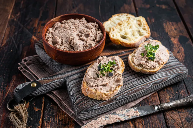 toasts with duck pate rillettes de canard on wooden board dark wooden background top view