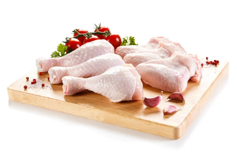 raw chicken legs and wings on cutting board