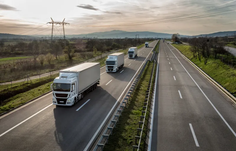 caravan or convoy of trucks in line on a country highway