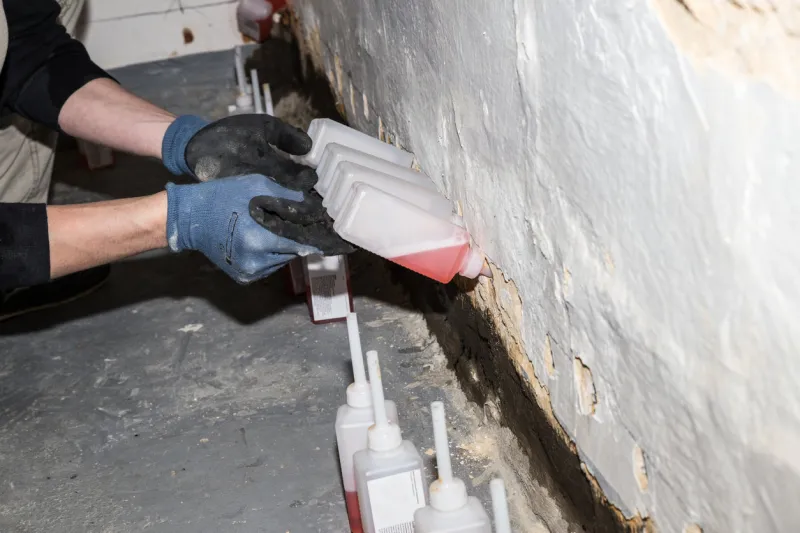 wall being damaged by dampness resulting in peeled of plaster and color in the bore holes in the wall synthetic resin is injected to establish a dampness barrier