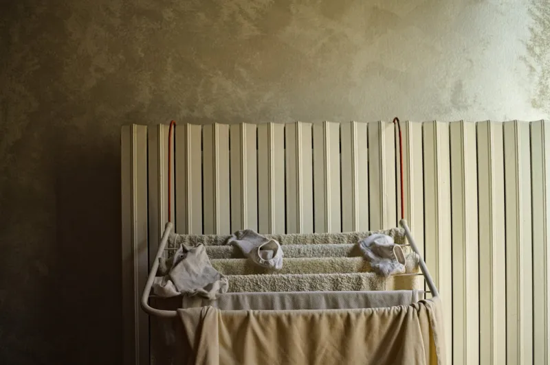 little clotheshorse hanging on the radiator with towels, socks and a t-shirt (pesaro, italy, europe)