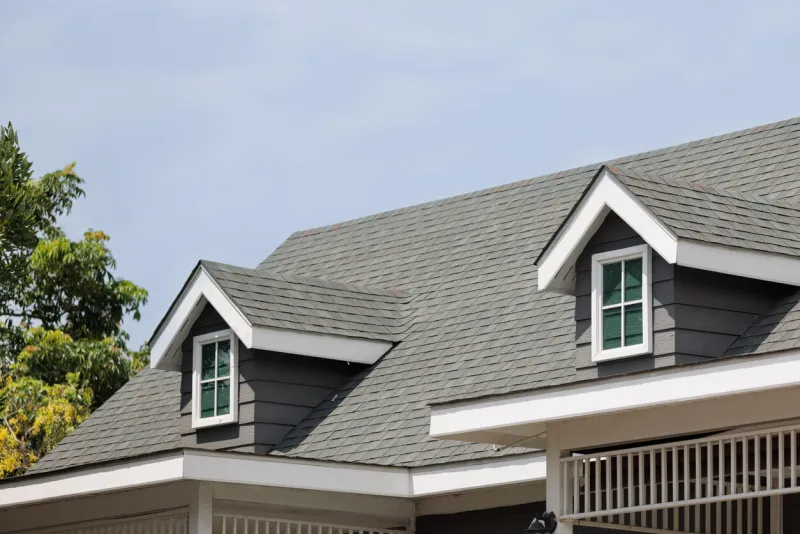 roof shingles with garret house on top of the house dark asphalt tiles on the roof background on afternoon time dark asphalt tiles on the roof background