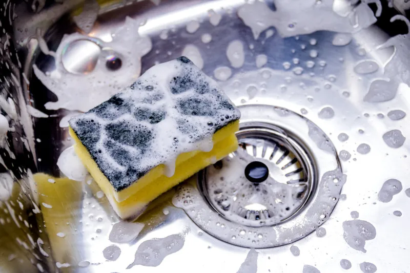 sponge in kitchen sink home cleaning concept