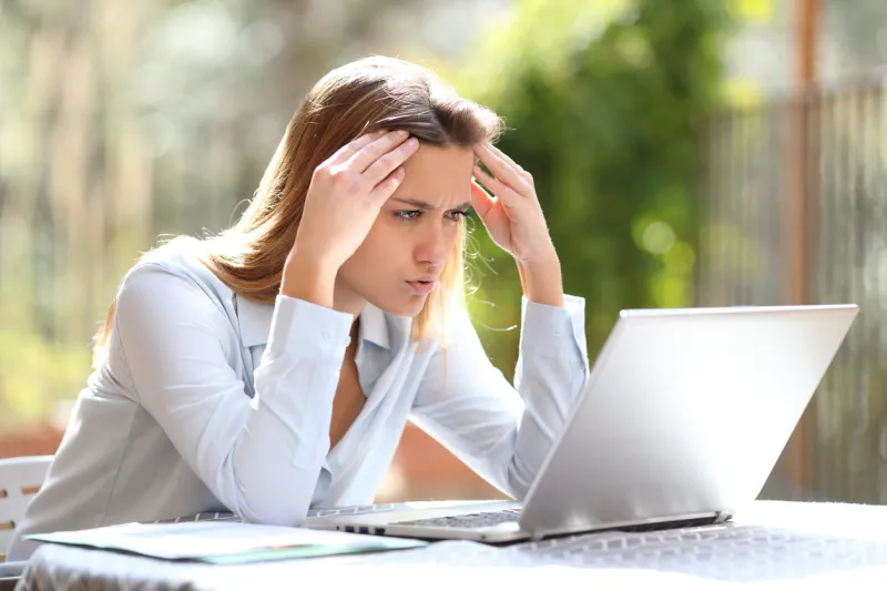worried freelancer checking bad news on laptop