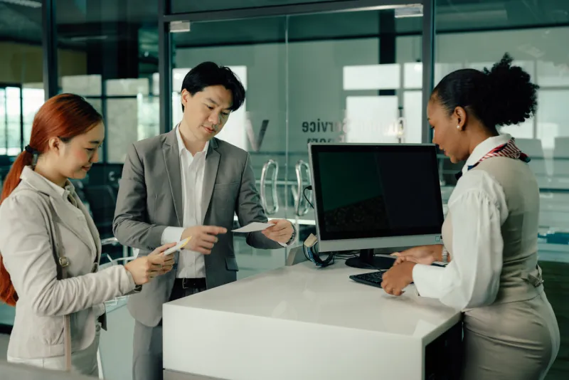 airplane passenger checking in giving her flight ticket to airline attendant