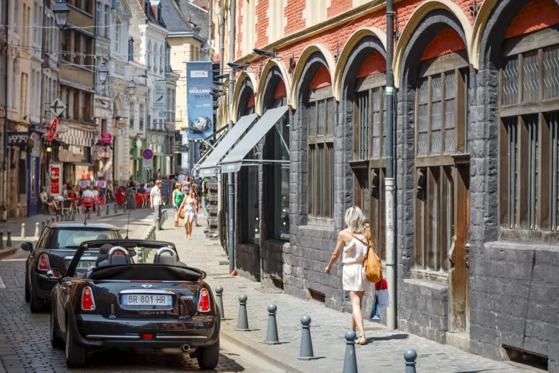 lille, france - july 20, 2013 woman shopping on rue de la monnaie outside musee hospice comtesse, the old hospital, in the old historic centre of lille, france