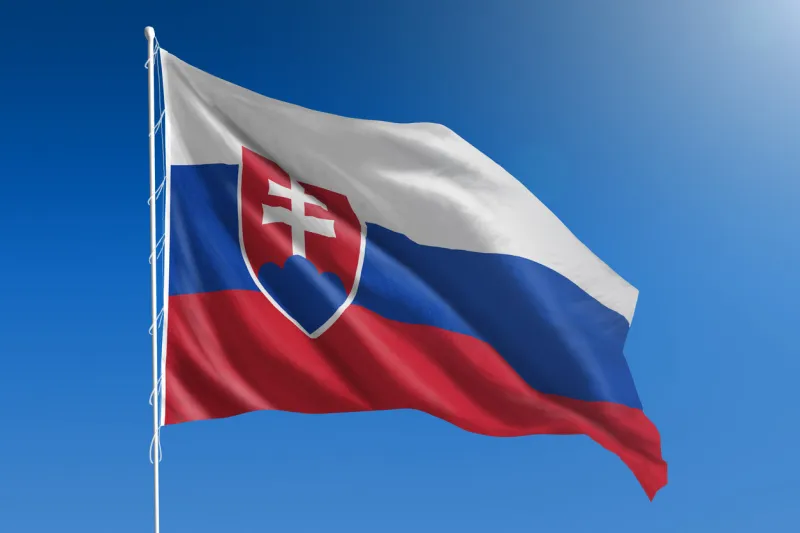 the national flag of slovakia blowing in the wind in front of a clear blue sky