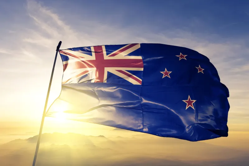 new zealand zealander flag on flagpole textile cloth fabric waving on the top sunrise mist fog