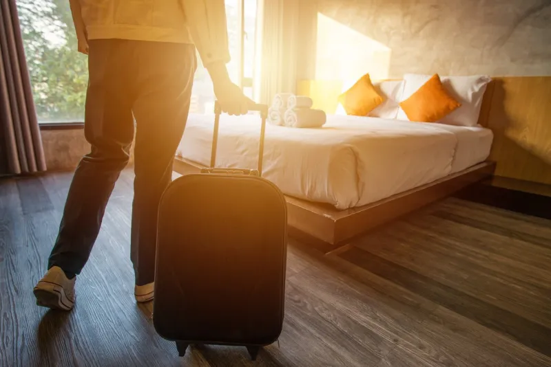 cropped shot of tourist woman pulling her luggage to her hotel bedroom after check-in