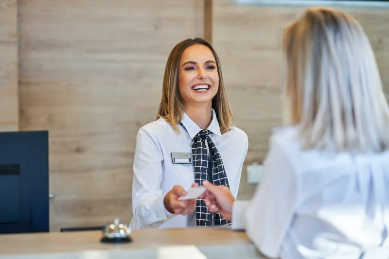 picture of receptionist and businesswoman at hotel front desk