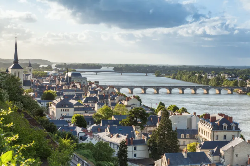 view of the french town of saumur in the loire river running through it