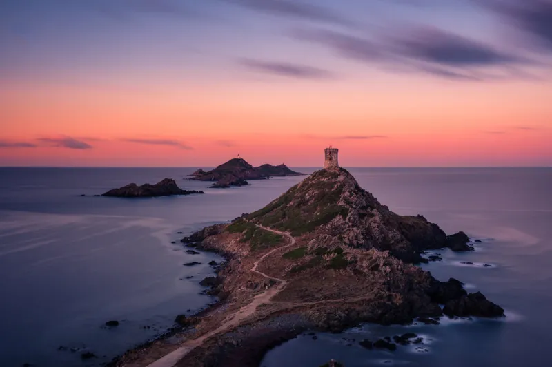 sunrise over the genoese tower and lighthouse at pointe de la parata and les iles sanguinaires near ajaccio in corsica