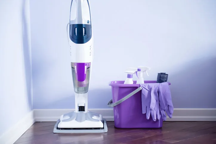 bucket with cleaning supplies collection purple background housework concept cleaning service steam mop cleaner