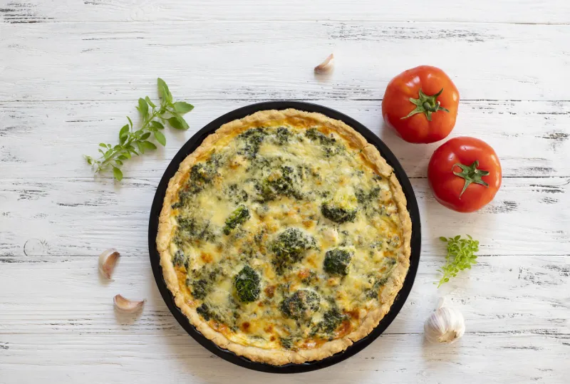 traditional french quiche with cheese, broccoli, spinach and chicken quiche lorraine french cuisine top view light wooden background