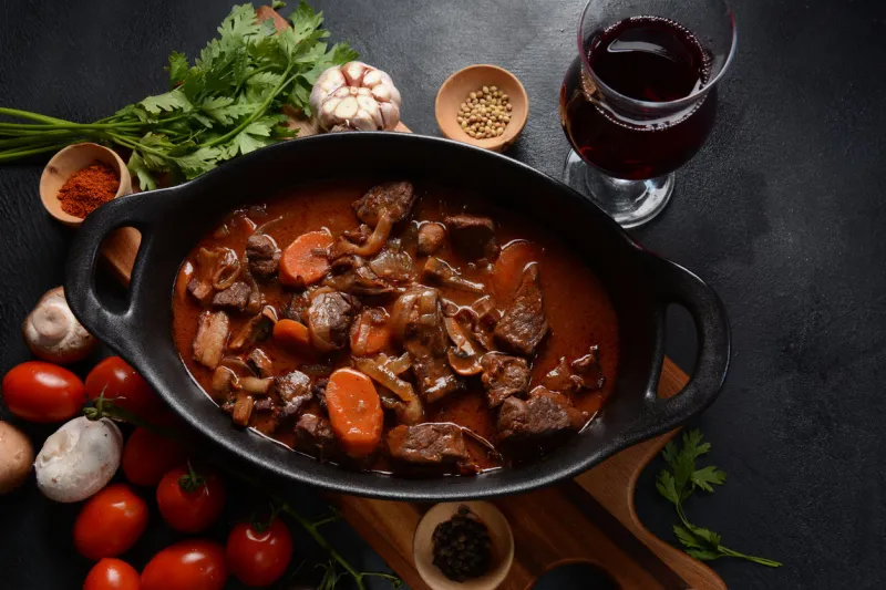 beef bourguignon stew with red wine ,carrots, onions, garlic, a bouquet garni, and garnished with pearl onions, mushrooms and bacon french cuisine- regional recipe from burgundy